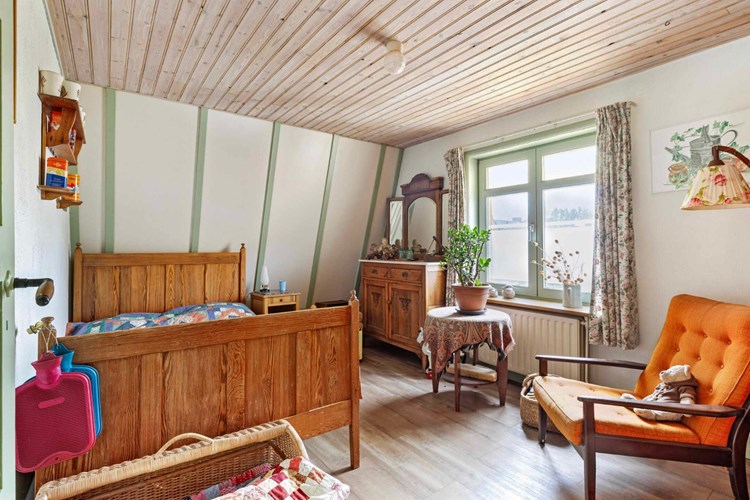 Slaapkamer gelegen aan de voorzijde, met een PVC-vloer, stucwerk wanden en een kraaldelen plafond. Daglicht via een hardhouten raamkozijn (draai-/kiep) met dubbele beglazing. 