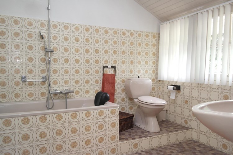 De badkamer is grotendeels betegeld en voorzien van een ligbad, een wastafel en 2e toilet (duoblok). 