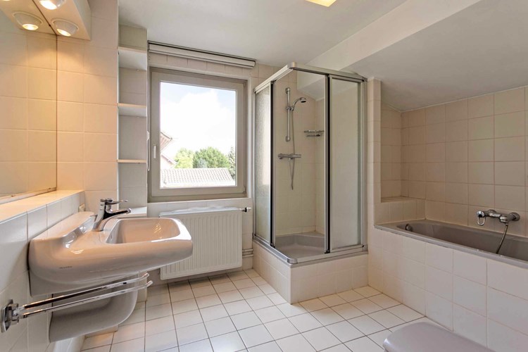 De badkamer heeft mechanische ventilatie en daglicht via een hardhouten raamkozijn (draai-/kiep) met dubbele beglazing.