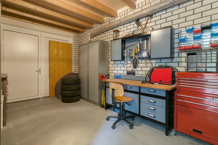 Garage met een betonvloer met vloerverwarming, geïsoleerde spouwmuren en plat dak. Voorzien van een uitstortgootsteen. Vanuit de garage met een deur rechtstreeks toegang tot de keuken. 