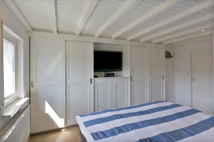 Deze slaapkamer is voorzien van een vaste op maat gemaakte wandkast. Daglicht via een tweetal hardhouten raamkozijnen met dubbele beglazing,  rolluiken met geïntegreerde vliegenhor. 