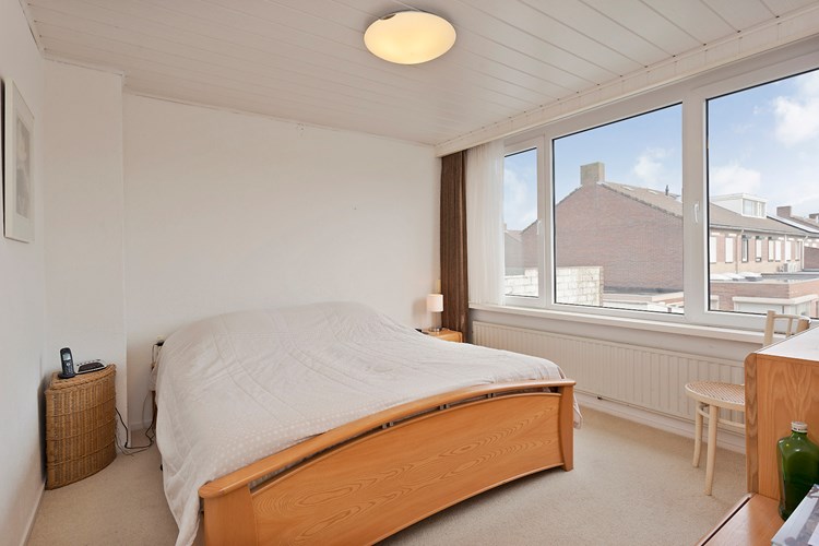 Slaapkamer I; gelegen aan de achterzijde, met vloerbedekking, stucwerk wanden en een licht schroten plafond. Daglicht via een kunststof raamkozijn (draai-/kiep) met dubbele beglazing en een rolluik. 