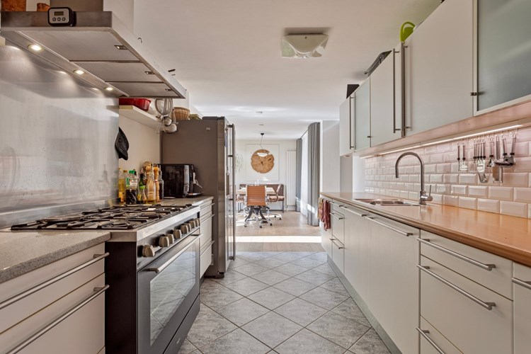 De keuken staat in open verbinding met de eetkamer. Met een tegelvloer, gedeeltelijk betegelde en stucwerk wanden en een stucwerk plafond. 