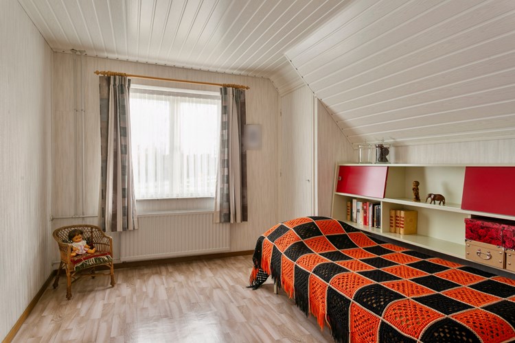 Slaapkamer gelegen aan de achterzijde, met een vinylvloer, behangen wanden en een kunststof schroten plafond. 