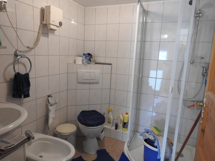 betegelde badkamer met wastafel, douche en toilet