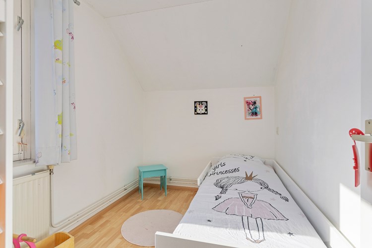 Slaapkamer gelegen aan de voorzijde, met een laminaatvloer, stucwerk wanden en een spuitwerk plafond. Daglicht via een hardhouten  raamkozijn met HR++ beglazing en een rolluik. 