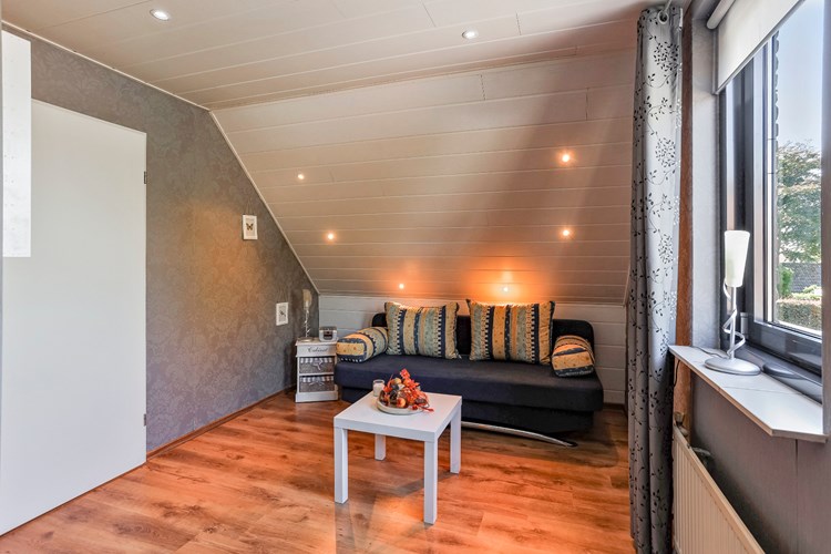 De slaapkamer gelegen aan de achterzijde is voorzien van een laminaatvloer, behangen wanden en een MDF plafond met inbouwspots. 