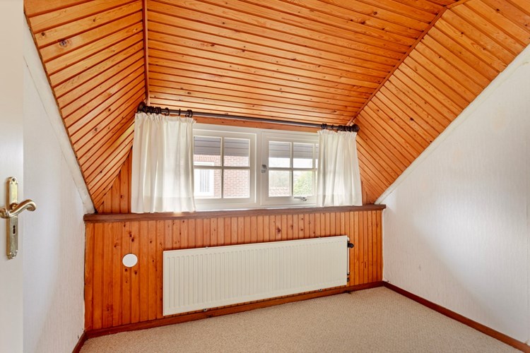 Slaap-/werkkamer, met vloerbedekking, behangen wanden en een schroten plafond. Daglicht via een dakkapel met hardhouten raamkozijnen met glas-in-roeden en enkele beglazing. 
