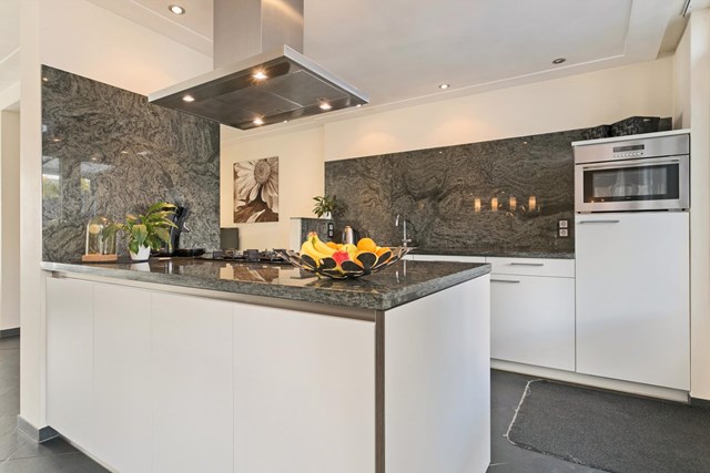 Het prachtige granieten aanrechtblad en de achterwand maken de keuken helemaal af. In deze keuken kan iedere (hobby)kok zijn hartje ophalen.