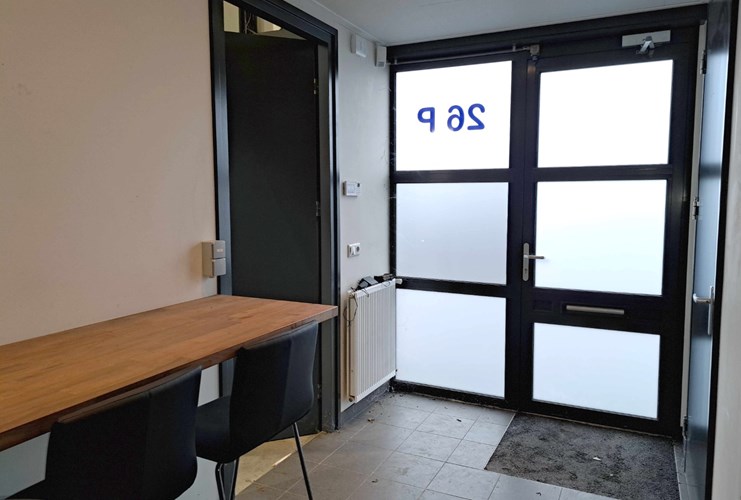 Via een aluminium deur met dubbel gematteerd glas toegang tot de entree. Vanuit de entree naar de bedrijfsruimte.