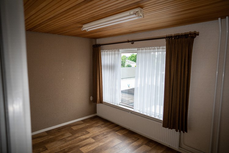 Slaapkamer gelegen aan de achterzijde, met een vinylvloer en een raamkozijn met dubbele beglazing en een rolluik. 