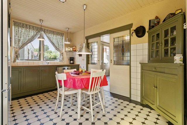 De prachtige en-suite deuren met glas-in-lood ramen zorgen voor een sfeervolle afscheiding tussen de keuken en de woonkamer.