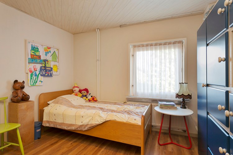 Slaapkamer gelegen aan de achterzijde, met een laminaatvloer, stucwerk wanden en een MDF plafond. Daglicht via een hardhouten raamkozijn met dubbele beglazing en een rolluik. 