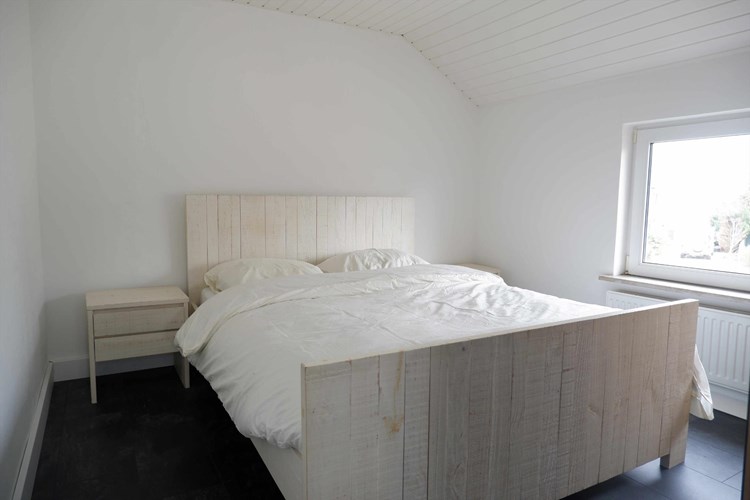 Slaapkamer gelegen aan de voorzijde, met een laminaatvloer, stucwerk wanden en een kunststof schroten plafond. 
