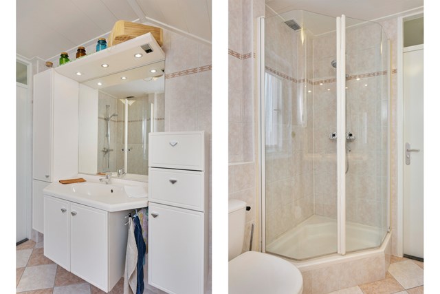 Detailfoto van de badkamer met badmeubel en douchecabine.
