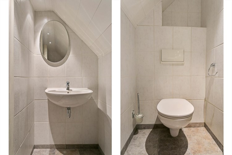 Op de verdieping ligt een volledig betegeld toilet met een MDF plafond. Een wandcloset met opzetplateau, een wastafel en een spiegel.