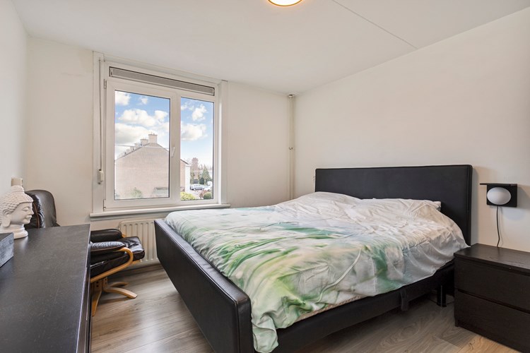 Slaapkamer gelegen aan de voorzijde, met een laminaatvloer, stucwerk wanden en een stucwerk plafond. Daglicht via een kunststof raamkozijn (draai-/kiep) met dubbele beglazing en een rolluik. 