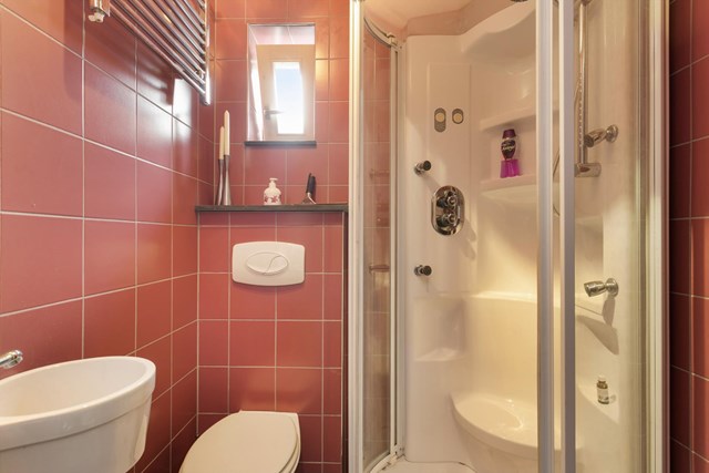 Deze badkamer op de begane grond heeft de beschikking over een stoom- en massagedouche, toilet en wastafel.