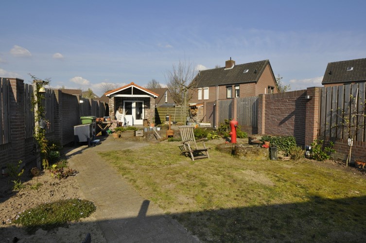 Halfvrijstaand geschakeld woonhuis met garage, carport, uitbouw en grote tuin. 