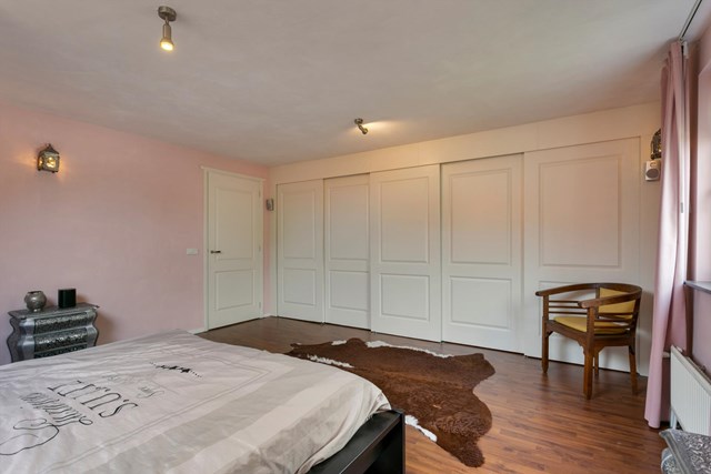 Deze grootste slaapkamer heeft een zeer praktische kastenwand over de volle breedte van de kamer.