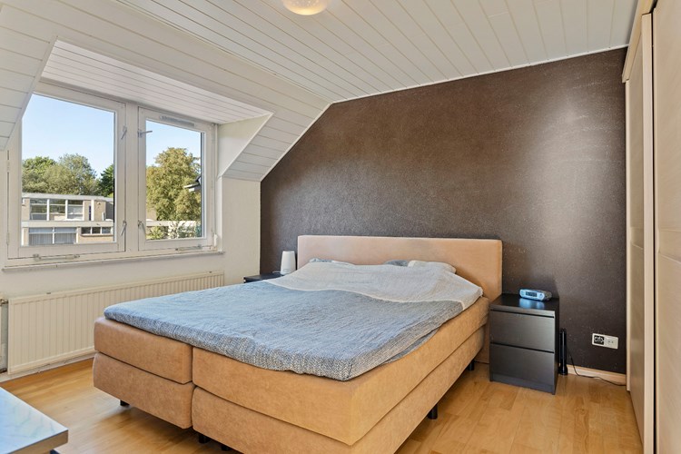 Slaapkamer gelegen aan de voorzijde, met een parketvloer, spachtelputz wanden en een MDF plafond. Daglicht via een dakkapel (vernieuwd in 2018) met hardhouten raamkozijnen, HR++ beglazing en een rolluik. 