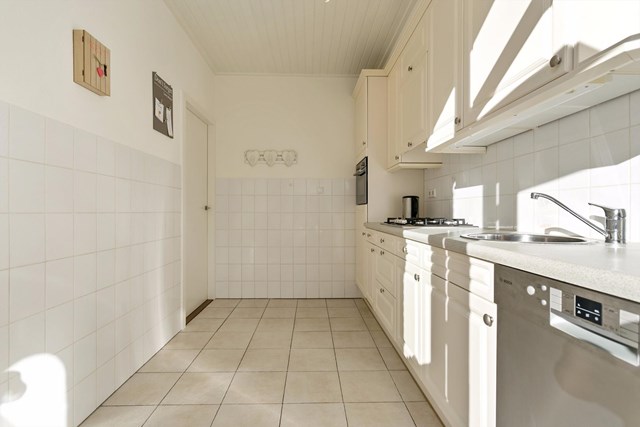 De keuken in wandopstelling is voorzien van een vaatwasser, combioven, koelkast, close-in boiler, gasfornuis en afzuigkap. 