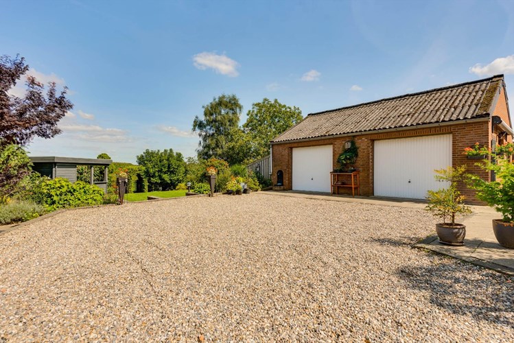 Zeer fraai gelegen half vrijstaande woonboerderij met separate dubbele garage en extern tegenover de woning gelegen agrarisch perceel/weiland. 