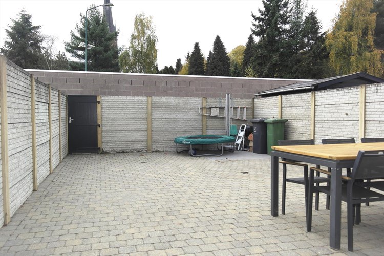 De achtertuin is omheind met een betonnen schutting. Volledig bestraat met cobblestones. Via een poort aan de achterzijde toegang tot de brandgang (achterom).