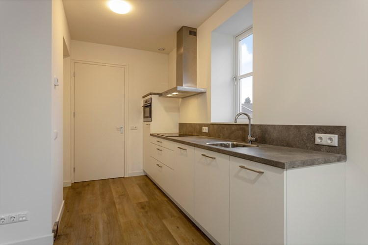 De keuken staat in open verbinding met de woonkamer en is voorzien van een moderne keukeninrichting. 
