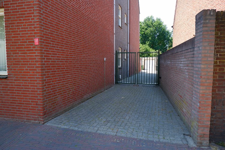 Aan de rechterzijde van het appartementencomplex via een royale oprit, middels een op afstand te bedienen elektrische poort, toegang tot de garagebox. 
