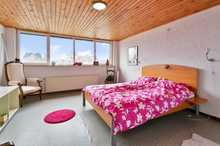 Slaapkamer I, gelegen in de opbouw, met een vinylvloer, stucwerk wanden en een schroten plafond. Daglicht via een groot hardhouten kozijn met dubbele beglazing en een rolluik. 