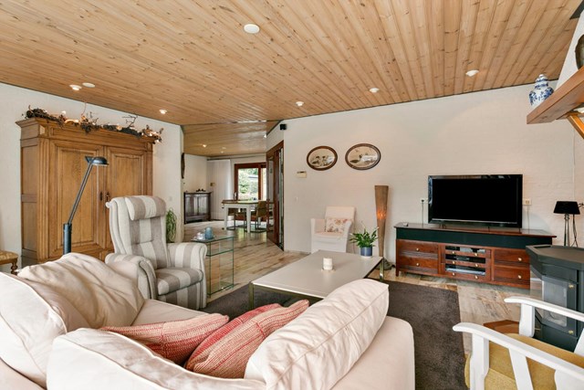 De woonkamer is voorzien van een prachtige natuurstenen vloer met vloerverwarming.