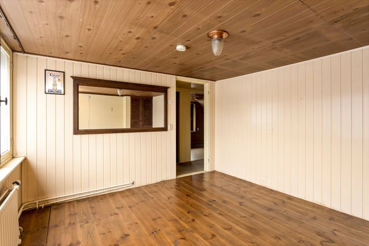 Slaapkamer gelegen aan de achterzijde, met houten vloerdelen,  kunststof schroten wanden en een schroten plafond. 