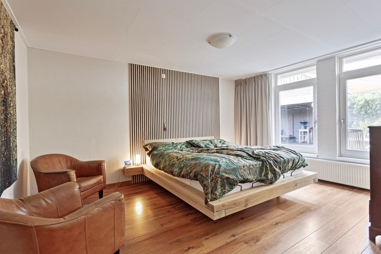 Grote slaapkamer met een laminaatvloer, MBI getexte- en stucwerk wanden en een stucwerk plafond. Daglicht via een tweetal hardhouten raamkozijnen met dubbele beglazing (HR++). 