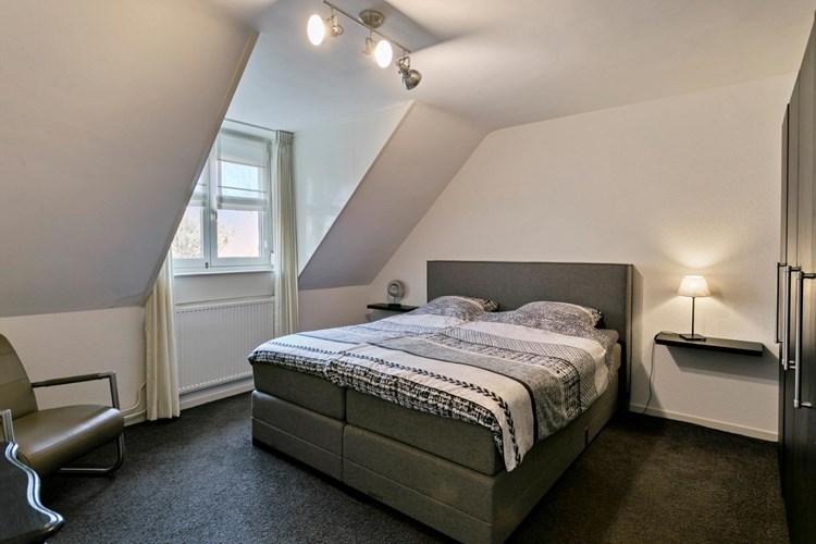 Slaapkamer I, gelegen aan de voorzijde, is voorzien van vloerbedekking, spachtelputz wanden en een spachtelputz plafond. 
