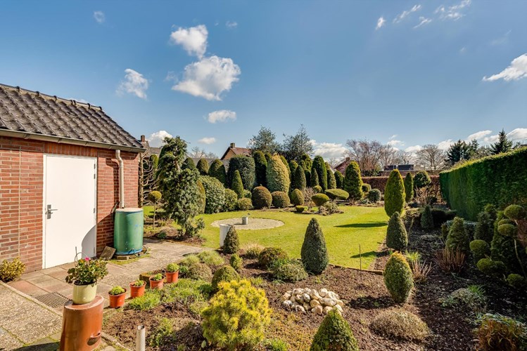 Vrijstaand woonhuis met aanbouw, garage, terrasoverkapping, berging, ondergrond erf en tuin. 