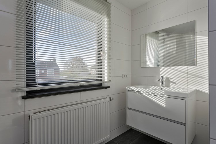 Met een badmeubel met een vaste wastafel en een spiegel. Natuurlijke ventilatie middels een hardhouten raamkozijn (draai-/kiep) met HR++ beglazing. 