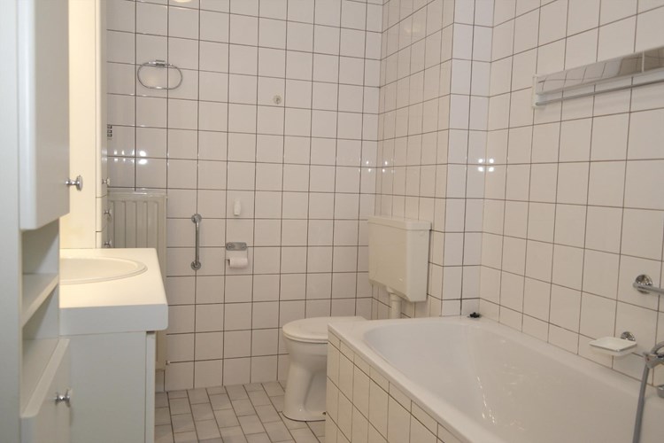 Een volledig licht betegelde badkamer en een spuitwerk plafond. Voorzien van een ligbad en een 2e toilet. 