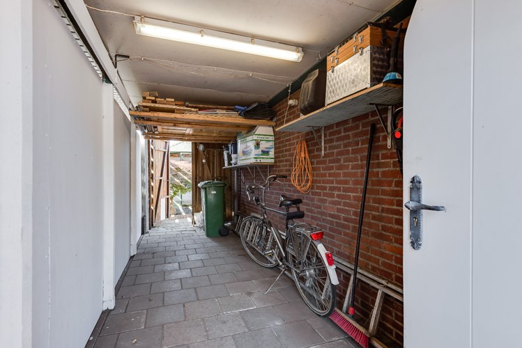 Half vrijstaande woning met aanbouw en garage, 4 slaapkamers en eigen achterom via een fietsenberging. 