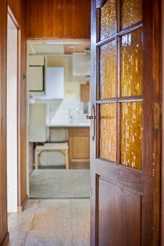Vanuit de entree met een deur met glas in roeden naar een portaal met toegang tot de woonkamer, keuken, toilet en wasruimte. 