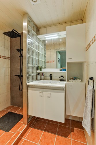 Voorzien van een inloopdouche met regendouche en een thermostaatkraan en een badmeubel met een wastafel en een spiegel.