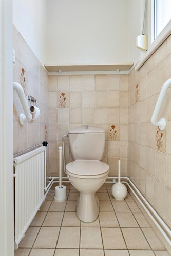 Het gedeeltelijk betegeld toilet is voorzien van een duoblok. Daglicht en natuurlijke ventilatie middels een kunststof raampje met dubbele beglazing en een rolluik.