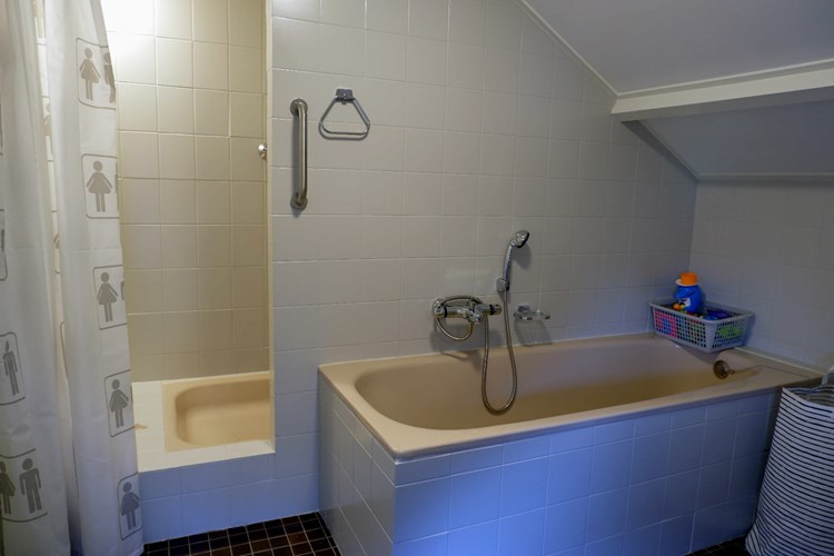Verder een ligbad met thermostaatkraan en een douche met thermostaatkraan. Hier bevindt zich ook een praktische muurkast. 