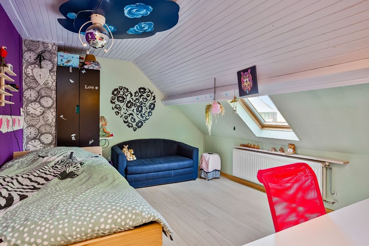 Slaapkamer gelegen aan de voorzijde, met een laminaatvloer, stucwerk wanden en een schroten plafond. Daglicht via een Velux dakraam met dubbele beglazing en een verduisteringsrolgordijn. 