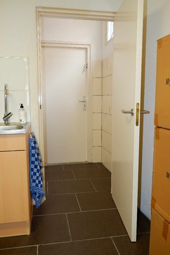 Vanuit de keuken met een deur naar een portaal met toegang tot het toilet en de nooduitgang aan de achterzijde.  
