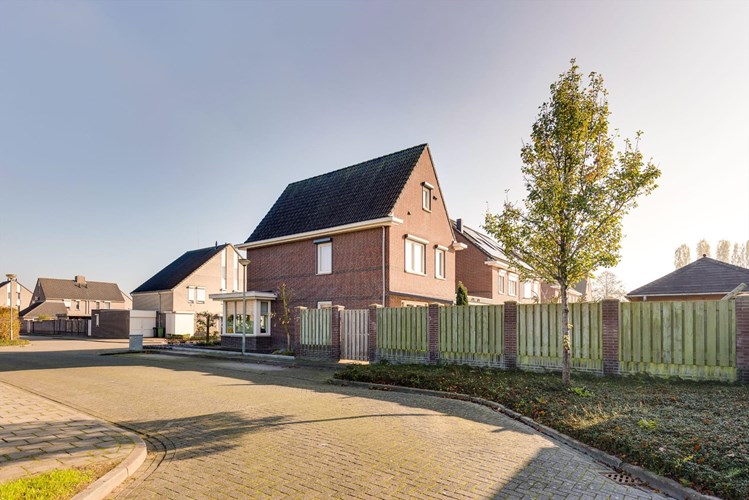 Op de hoek van de straat gelegen vrijstaand met de garage geschakelde woning met fraai aangelegde tuin. 