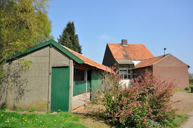 Vrijstaand woonhuis met schuren, overige aanhorigheden, ondergrond erf en tuin. 