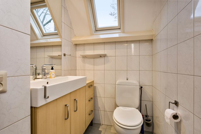 Op de verdieping is ook een ruime, geheel betegelde  toiletruimte met een mooi en praktisch badmeubel.