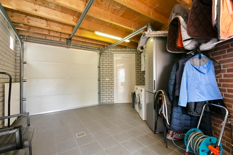 De garage is volledig geïsoleerd. Met een tegelvloer en een radiator. Hier bevindt zich ook de aansluiting van de wasapparatuur en en de Vaillant Ecotec Classic HR combiketel (2016). 