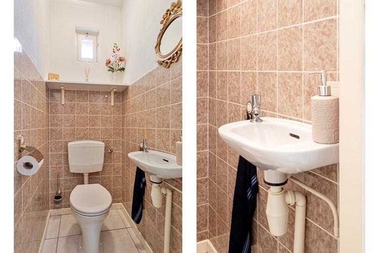Het toilet is voorzien van een lichte tegelvloer, gedeeltelijk betegelde wanden en een spuitwerk plafond. Met een fonteintje en een raampje. 